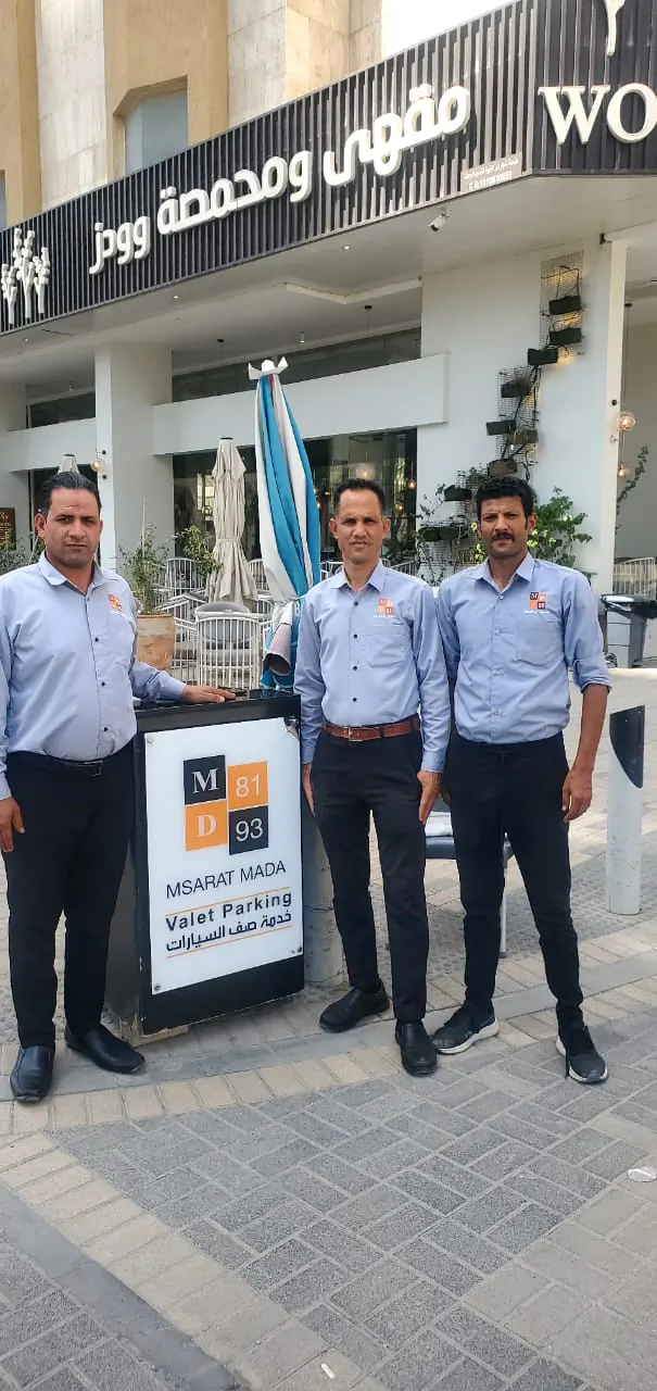 فريق مسارات مدى أمام مطعم مع لوحة خدمة صف السيارات